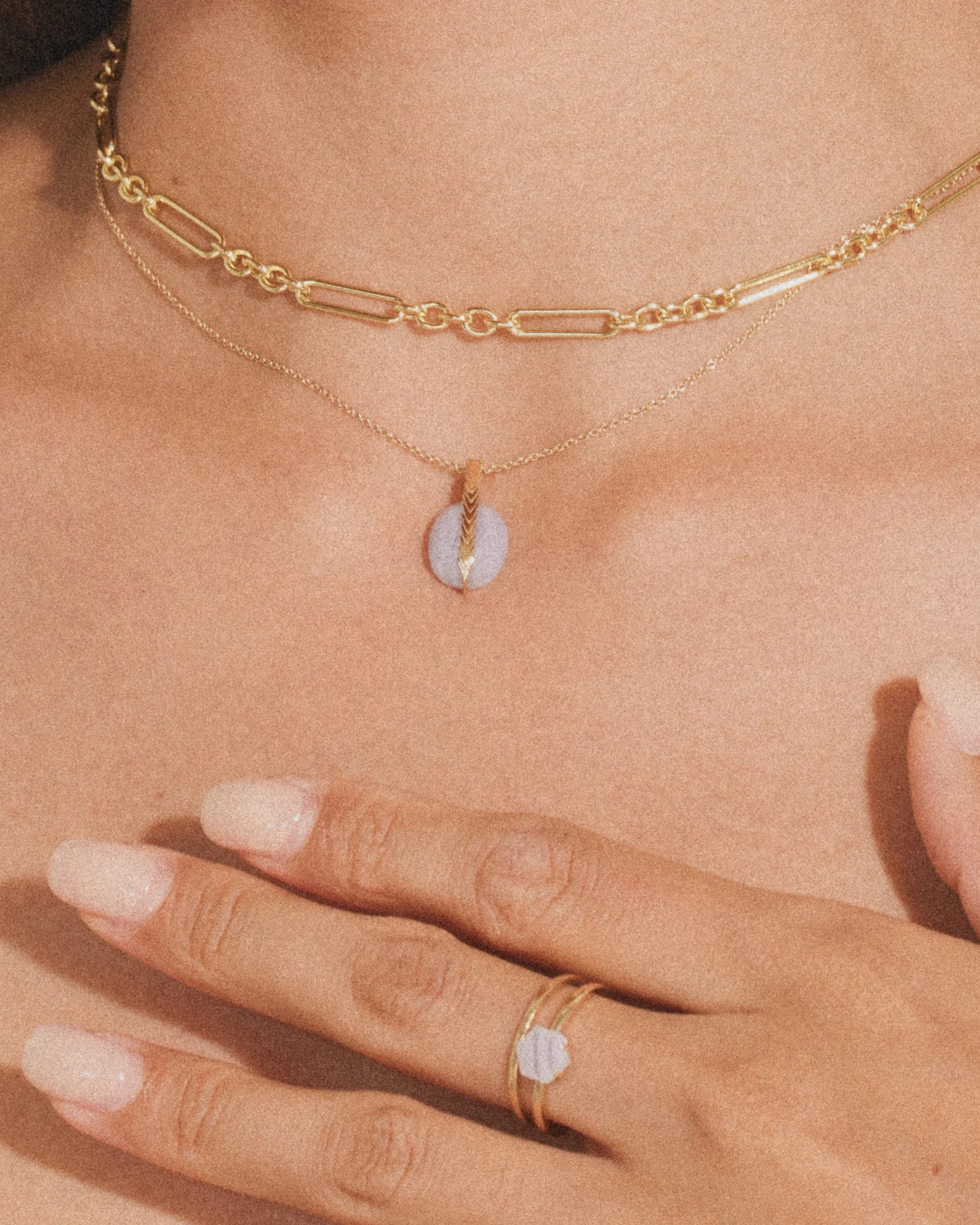 14K gold ring with oval white gemstone, slim band on hand