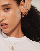 14K gold round pendant necklace with detailed medallion on fine chain
