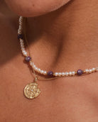 14K gold round medallion pendant on pearl and purple beaded necklace