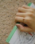 14K gold opal ring on hand, small oval opal gemstone on slim band